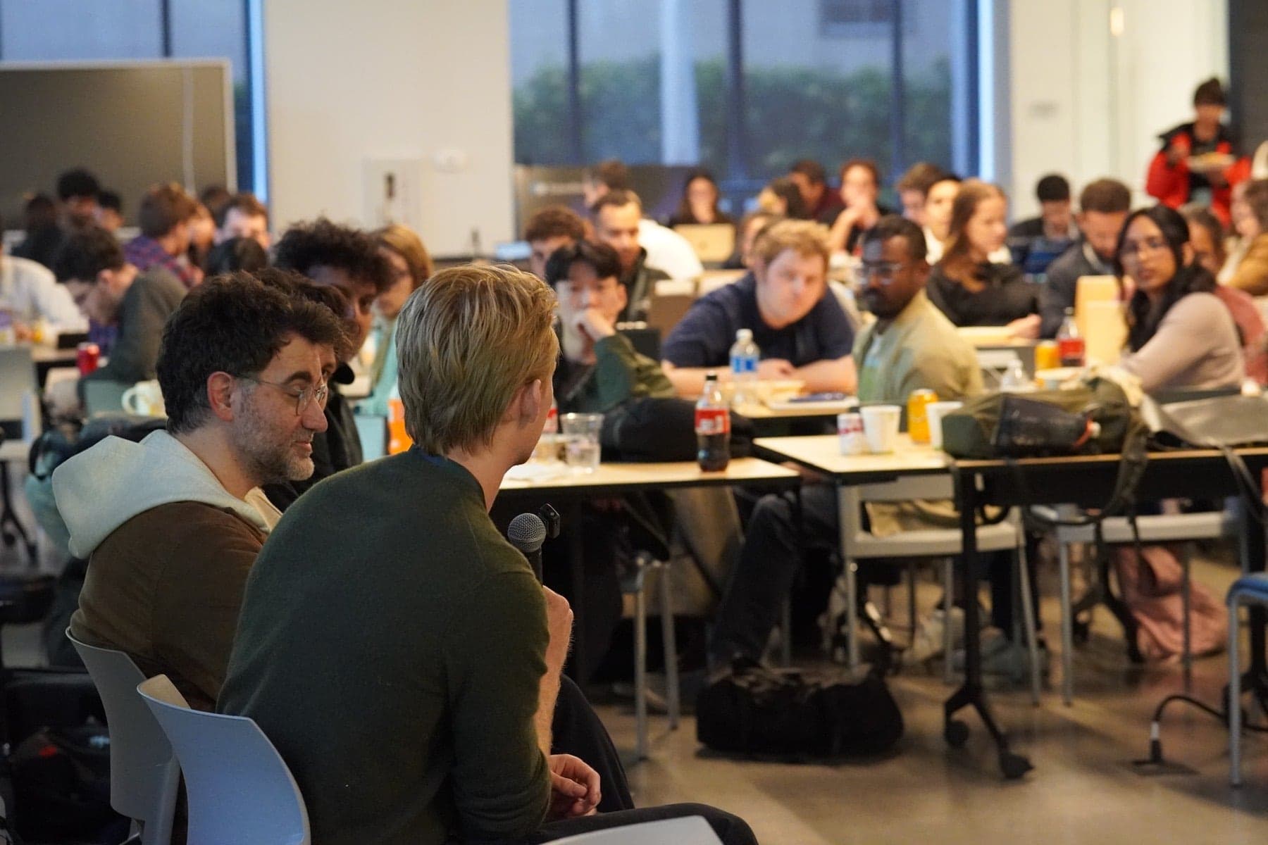 A full room of builders listening to a speaker at a HackerSquad event